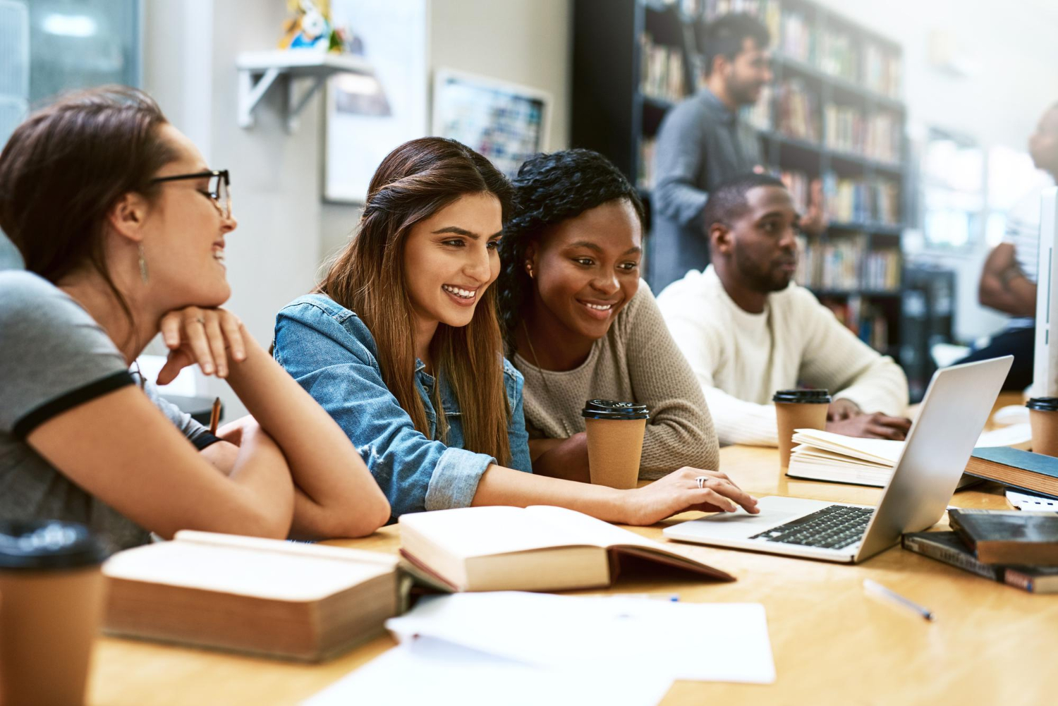 Étudiantes à la bibliothèque avec ordinateur portable et étudiant pour examen ou recherche pour projet avec éducation